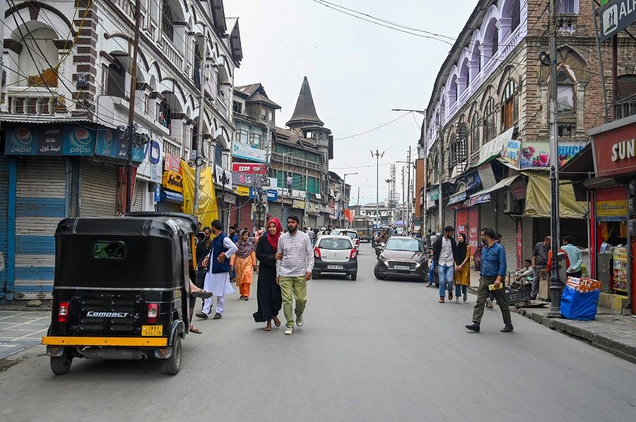 People walk along a street near a closed market in Srinagar, India, on 17 June 2022. (Tauseef Mustafa/AFP)
