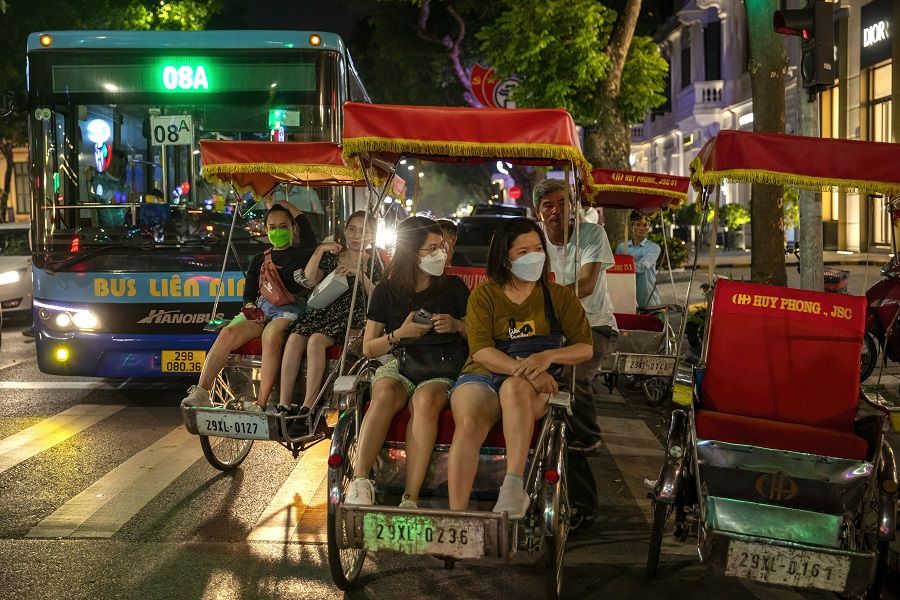 People enjoy a cyclo ride near Hoan Kiem Lake in Hanoi, Vietnam, on 11 June 2022. (Maika Elan/Bloomberg)