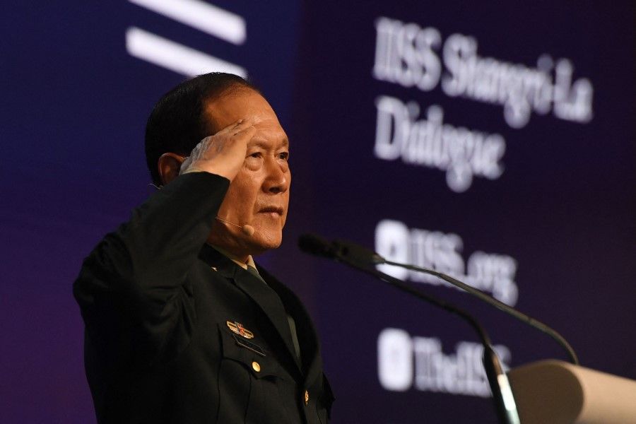 China's Defence Minister Wei Fenghe salutes from the podium at the Shangri-La Dialogue summit in Singapore on 12 June 2022. (Roslan Rahman/AFP)