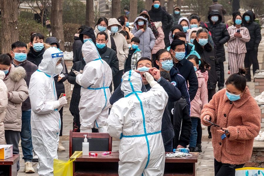 Residents queue to undergo nucleic acid tests for Covid-19 in Anyang, Henan province, China, on 26 January 2022. (AFP)