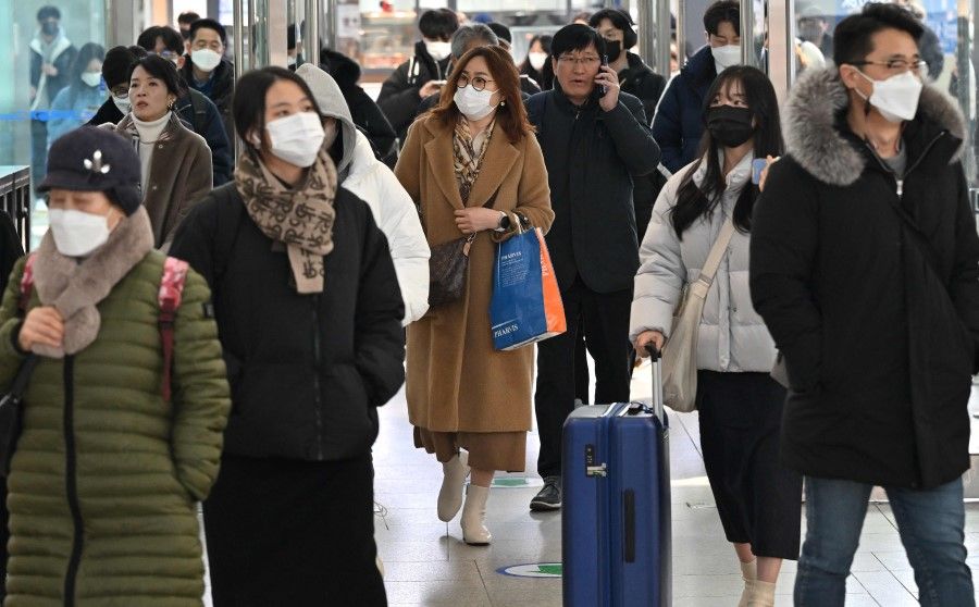 People wearing face masks make their way at Seoul railway station in Seoul on 30 January 2023, after South Korea lifted its indoor mask mandate as Covid cases dwindled. (Jung Yeon-je/AFP)