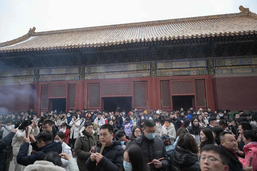 People gather to burn incense sticks and offer prayers at Yonghe Temple, also known as Lama Temple, on the first day of the new year in Beijing on 1 January 2024. (Pedro Pardo/AFP)