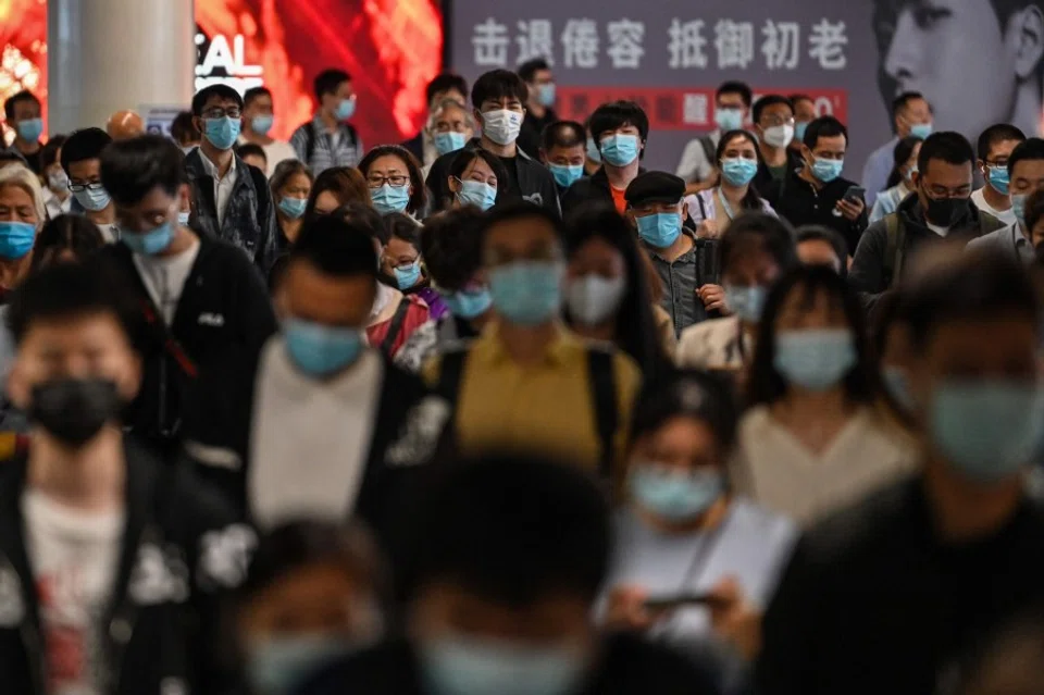 People walk in a subway station in Shanghai on 12 October 2021. (Hector Retamal/AFP)