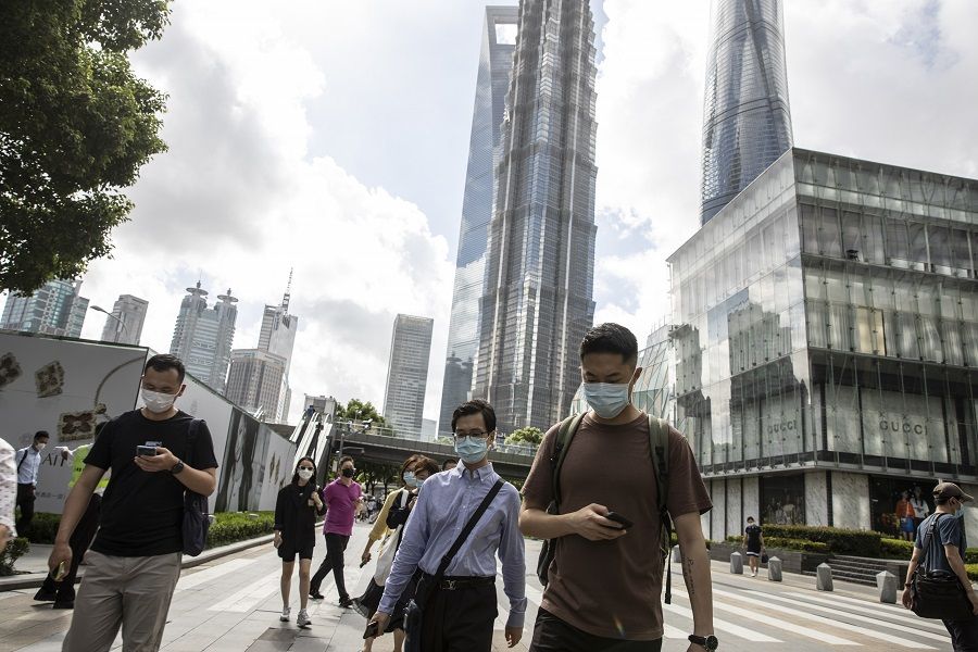 Pedestrians wearing protective masks make their way through the financial district during the morning rush hour in Shanghai, China, on 6 August 2021. (Qilai Shen/Bloomberg)