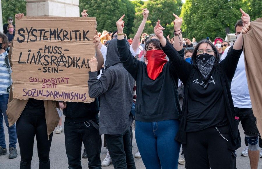 Left-wing protesters shout slogans against the supporters of the Austrian Freedom Party (FPOe) attending a protest against the governments restrictions against the coronavirus pandemic at Helden square in front the Hofburg palace in Vienna, Austria, 20 May 2020. (Joe Klamar/AFP)