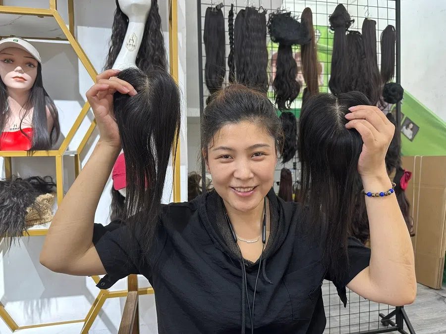 Miao Miao, who is head of the Lai Yuan Wig Factory in Xuchang, showcasing the wigs they produced. 