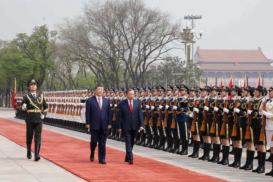 This photo taken and released by the Vietnam News Agency (VNA) on 15 April 2026, shows Chinese President Xi Jinping (centre) and Vietnam's President To Lam (right) inspecting honour guards at the Great Hall of the People in Beijing. (VNA/AFP)