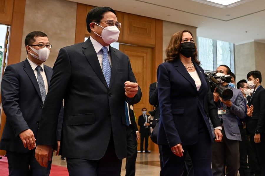 U.S. Vice President Kamala Harris (right) walks with Vietnam's Prime Minister Pham Minh Chinh (centre) in the Government office in Hanoi, Vietnam, 25 August 2021. (Manan Vatsyayana/Pool via Reuters)