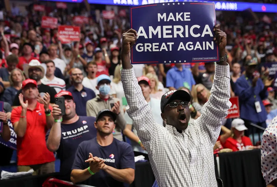 A supporter of US President Donald Trump holds up a "Make America Great Again" sign as the president arrives at his first re-election campaign rally in several months in the midst of the coronavirus outbreak, at the BOK Center in Tulsa, Oklahoma, US, on 20 June 2020. (Leah Millis/Reuters)