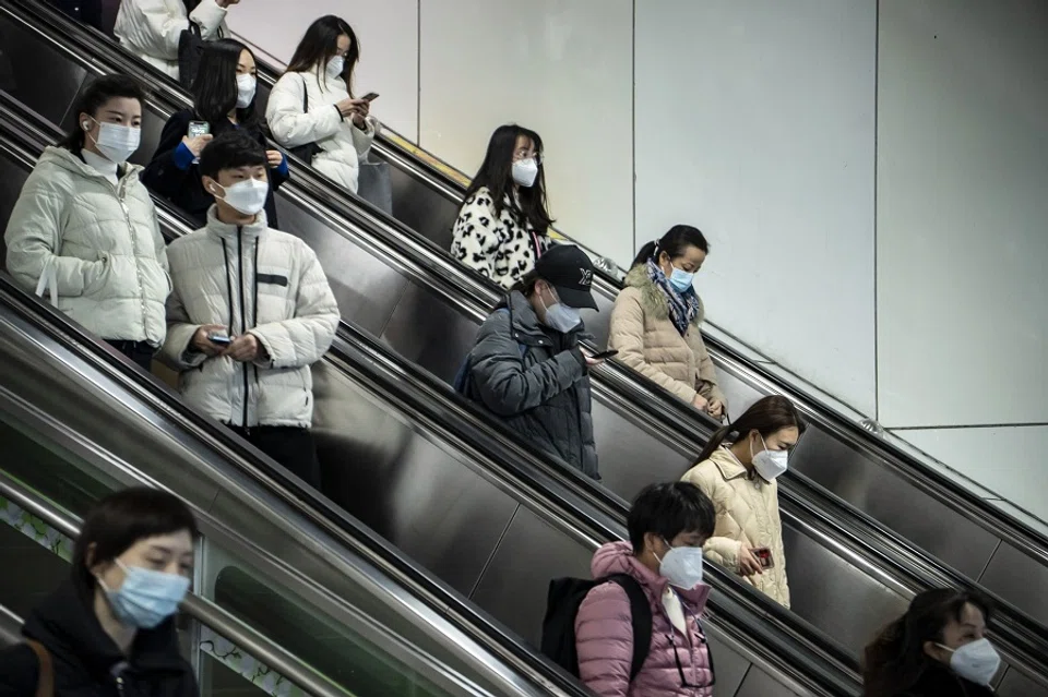 Commuters ride an escalator in Shanghai, China, on 20 December 2022. (Qilai Shen/Bloomberg)