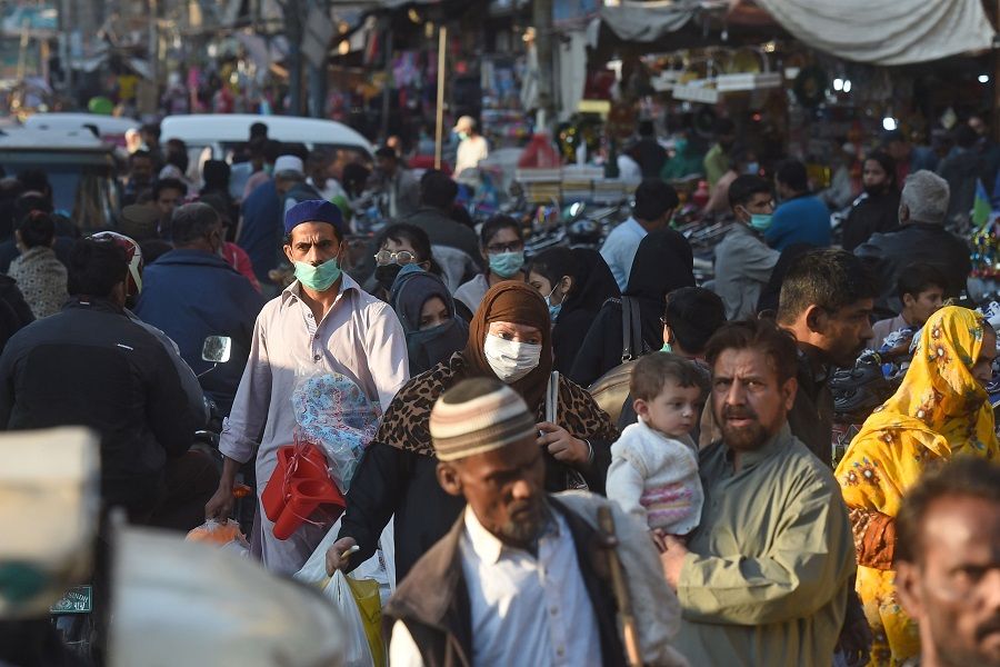 Shoppers wearing face masks as a preventive measure against the Covid-19 coronavirus walk through a market in Karachi, Pakistan, on 26 November 2020. (Asif Hassan/AFP)