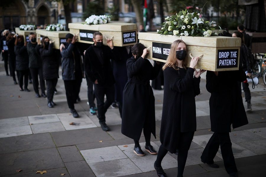 Members of Global Justice Now protest carrying coffins through Westminster to highlight the global number of deaths from the coronavirus disease, in London, Britain, 12 October 2021. (Hannah McKay/Reuters)
