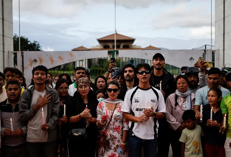 People holding lit candles sing the national anthem as they take part in a candlelight vigil in memory of people who died during the protest against anti-corruption triggered by a social media ban in Kathmandu, Nepal, on 13 September 2025. (Navesh Chitrakar/Reuters)