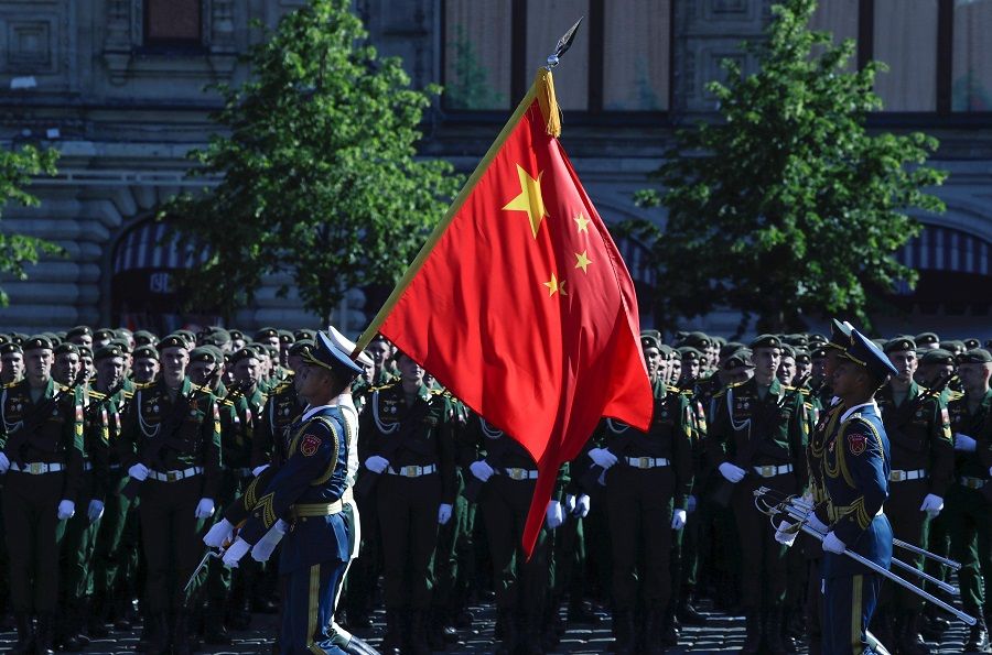 Soldiers from China's People's Liberation Army carry a state flag at Red Square prior to a military parade, which marks the 75th anniversary of the Soviet victory over Nazi Germany in World War II, in Moscow on 24 June 2020. (Pavel Golovkin/POOL/AFP)