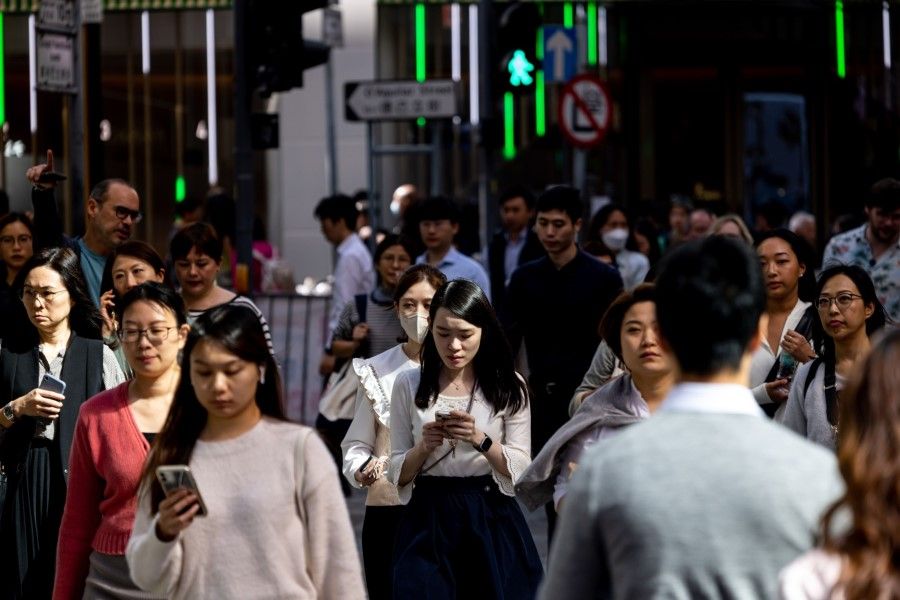 Office workers walk on a street during lunch hour in the Central district in Hong Kong, China, on 20 November 2023. (Paul Yeung/Bloomberg)