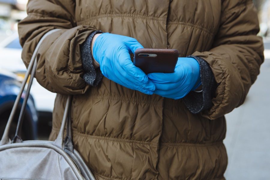 Anyone with a smartphone can broadcast news online and the footages they take down can easily spread like wildfire. In this photo, a person wears protective gloves while using a mobile phone in New Rochelle, New York, U.S., on 16 March 2020. (Angus Mordant/Bloomberg)