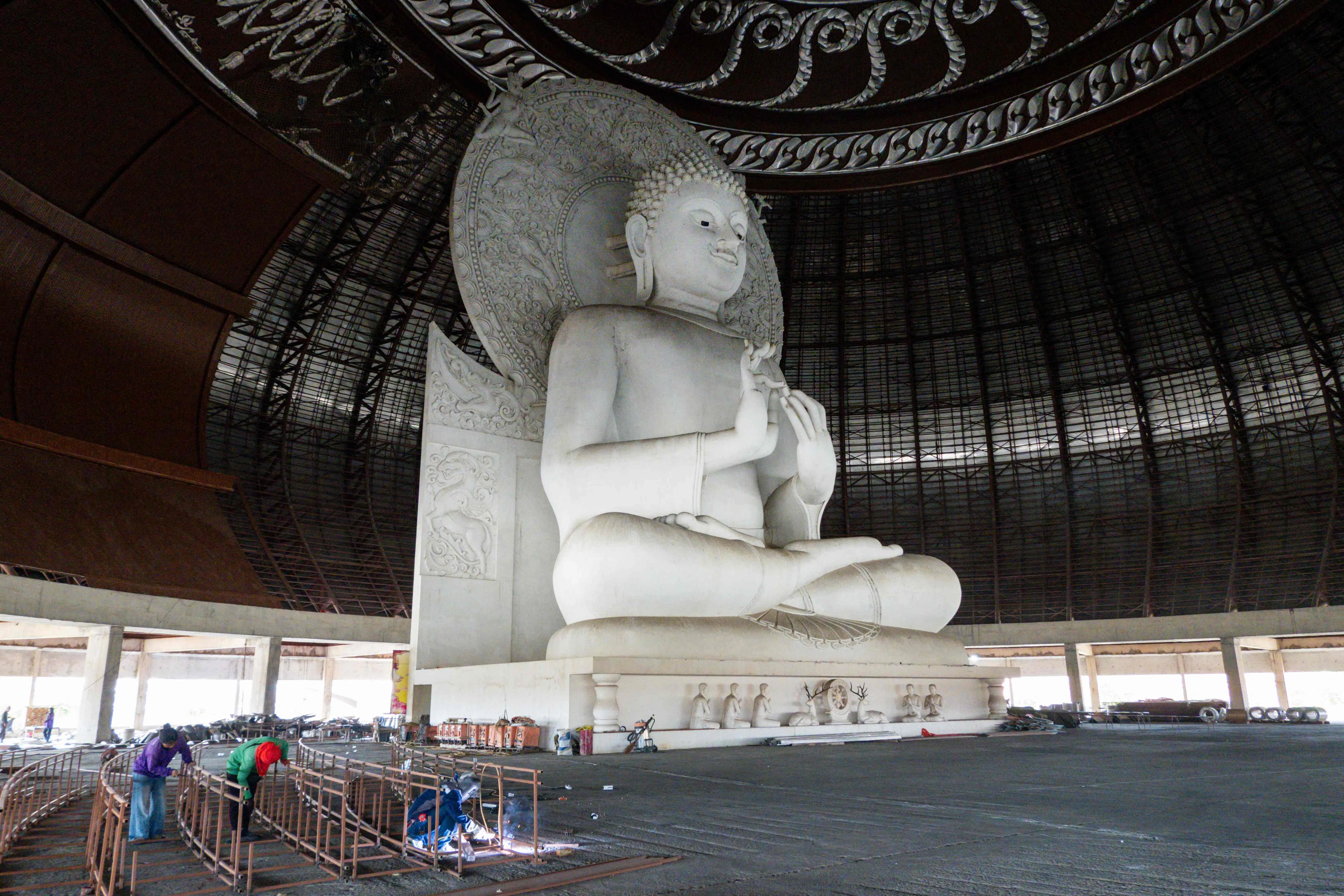 Labourers work next to a Buddha statue to complete the interior of the large central dome at the Wat Phra Phuttha Saeng Tham Buddhist complex in Thailand’s central Saraburi province on 29 July 2026.