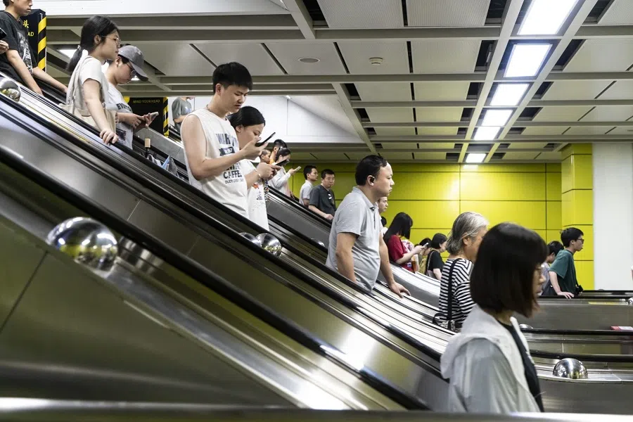 Pedestrians ride escalators at a subway station in Guangzhou, China, on 30 July 2024. (Qilai Shen/Bloomberg)