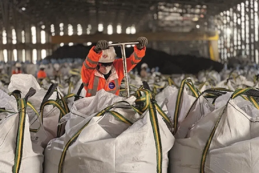 In June 2024, processed copper concentrate is packed in white plastic bags at the Kamoa copper mine’s concentrate warehouse; local employees are taking samples for composition testing.