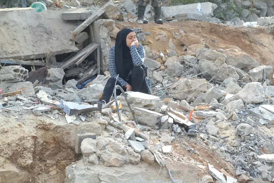 A woman reacts while sitting on the rubble at the site of an overnight Israeli strike in Lebanon’s Akkar region on 12 November 2024, amid the ongoing war between Israel and Hezbollah. (Fathi Al-Masri/AFP)