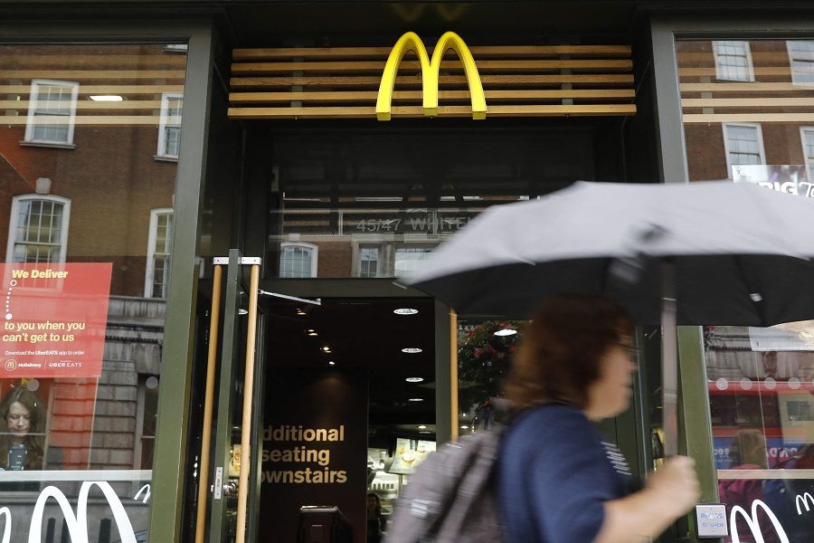In this file photo taken on 4 September 2017, a woman walks past a McDonald's branch in central London, UK. (Tolga Akmen/AFP)