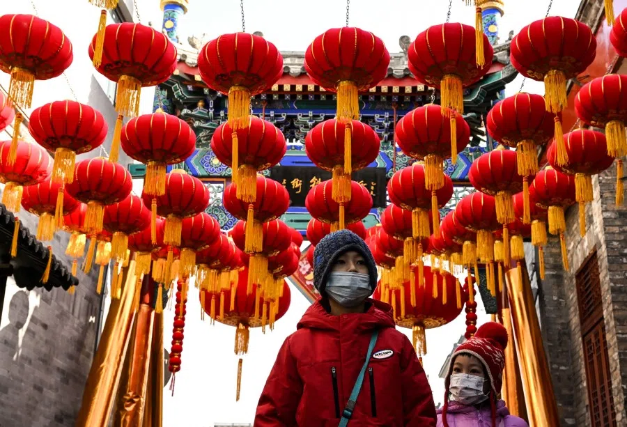 Children walk under lanterns along an alley ahead of the lunar new year in Beijing on 21 January 2023. (Noel Celis/AFP)