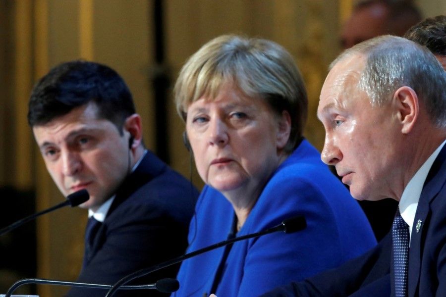 Ukraine's President Volodymyr Zelenskyy, former German Chancellor Angela Merkel and Russia's President Vladimir Putin attend a joint news conference after a Normandy-format summit in Paris, France, 10 December 2019. (Charles Platiau/Reuters)