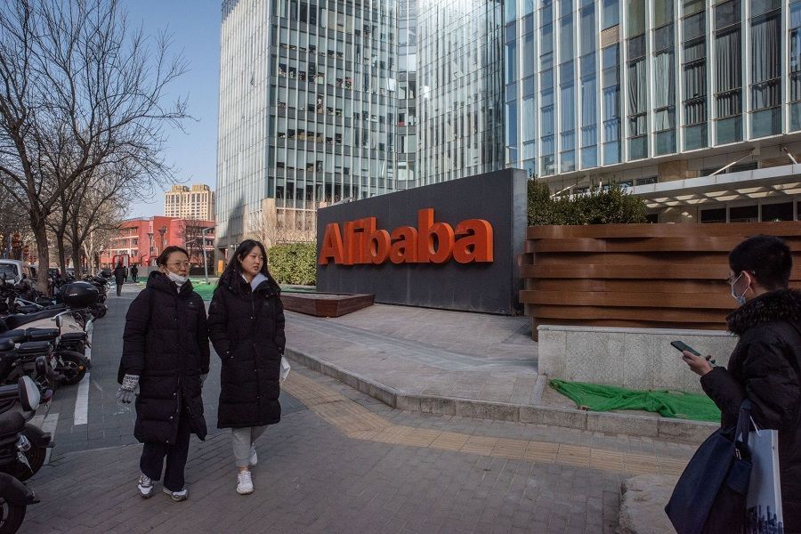 People walk past signage at the Alibaba Group Holding Ltd. offices in Beijing, China, on 17 January 2023. (Bloomberg)