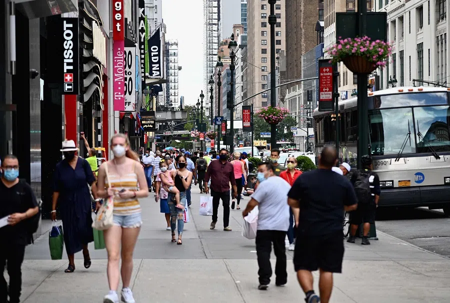 People wearing face masks carry shopping bags as they walk near Herald Square on 25 June 2020 in New York City. (Angela Weiss/AFP)
