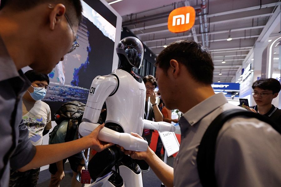 Visitors touch humanoid robot CyberOne developed by Xiaomi at the World Robot Conference 2023, in Beijing, China, 17 August 2023. (Tingshu Wang/Reuters)