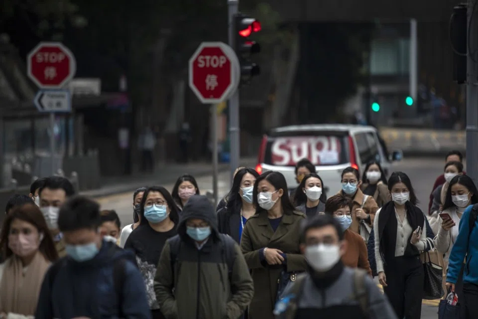 Pedestrians along a road in Hong Kong, China, on 15 February 2022. (Paul Yeung/Bloomberg)