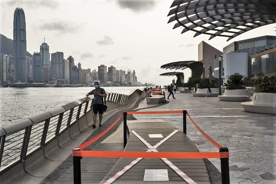 Barrier tape cordons off parts of benches to enforce safe distancing measures along the Tsim Sha Tsui waterfront in Hong Kong, on 21 April 2020. (Roy Liu/Bloomberg)