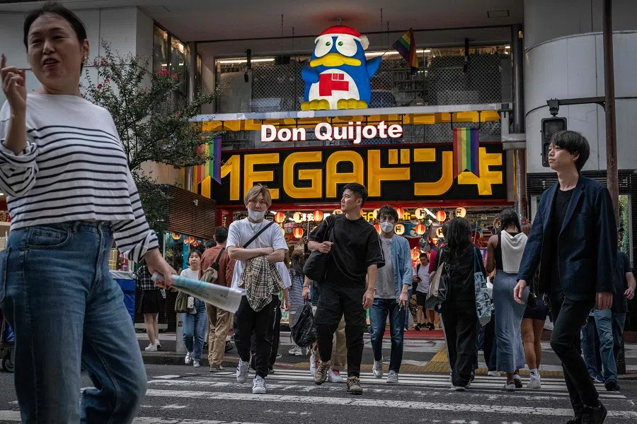 People cross a street in front of a Don Quijote store in Shibuya area in Tokyo on 3 October 2024. (Yuichi Yamazaki/AFP)