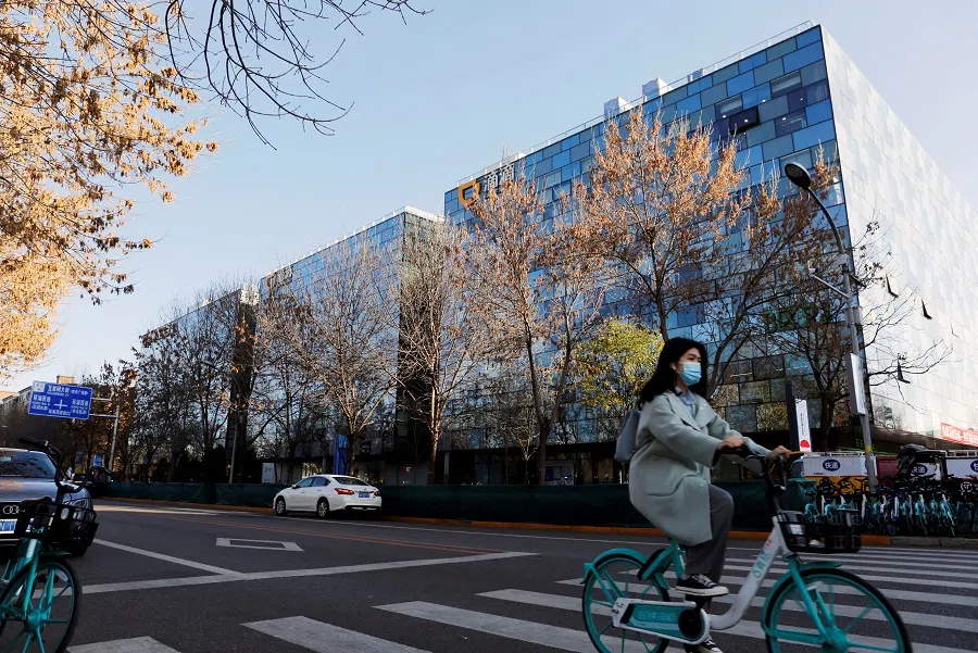 A woman rides a Didi shared bicycle past the headquarters of Didi Chuxing in Beijing, China, 20 November 2020. (Florence Lo/File Photo/Reuters)