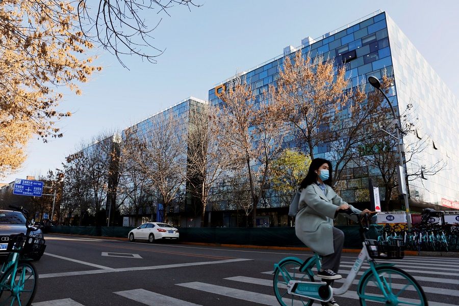 A woman rides a Didi shared bicycle past the headquarters of Didi Chuxing in Beijing, China, 20 November 2020. (Florence Lo/File Photo/Reuters)