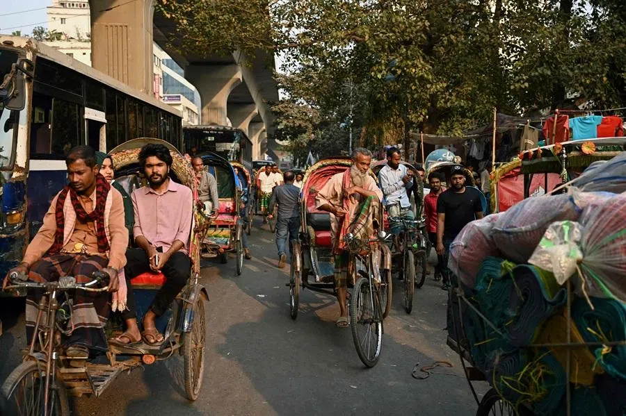 Rickshaw pullers wait for customers along a street in Dhaka on 16 February 2026. (Mohd Rasfan/AFP)