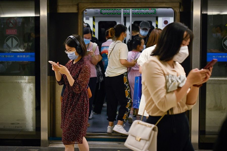 People walk in a subway station in Beijing, China, on 15 July 2022. (Wang Zhao/AFP)