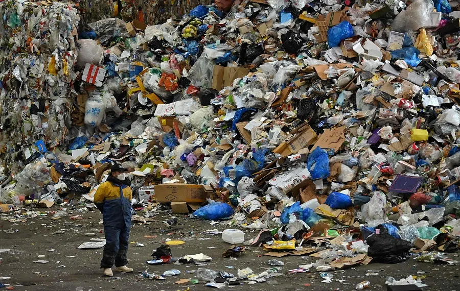 A worker stands beside a rubbish pile at a waste recycling centre in the Songpa-gu district of Seoul, South Korea, on 16 February 2021. (Jung Yeon-je/AFP)