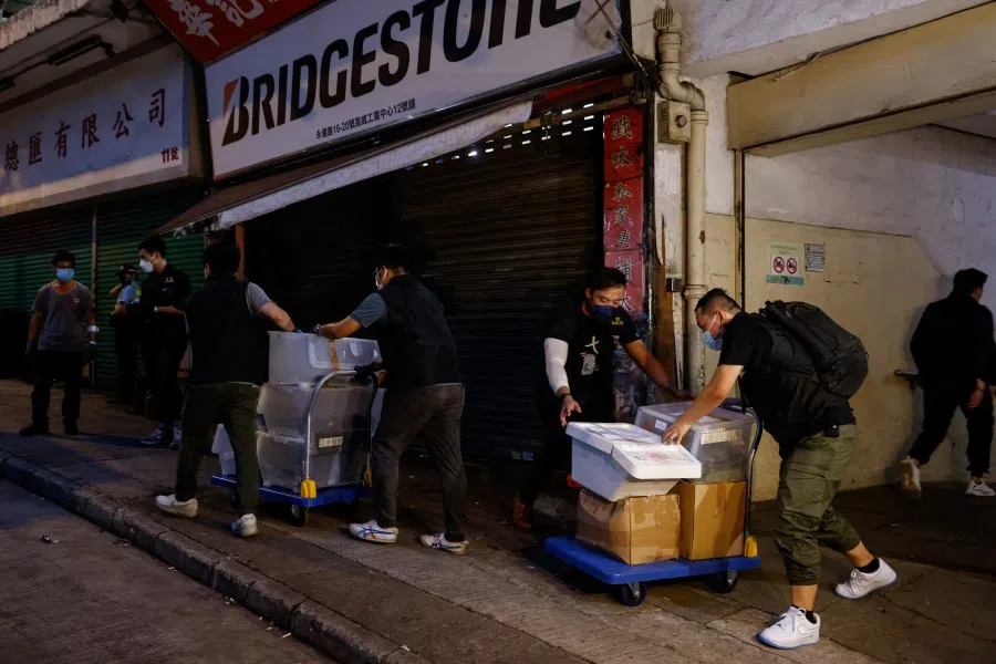 Movers collect boxes of evidence after the arrest of five men on suspicion of conspiracy to collude with foreign forces and acts with seditious intent, two days after the police issued arrest warrants and bounties against eight overseas activists for national security, in Hong Kong, China, on 5 July 2023. (Tyrone Siu/Reuters)