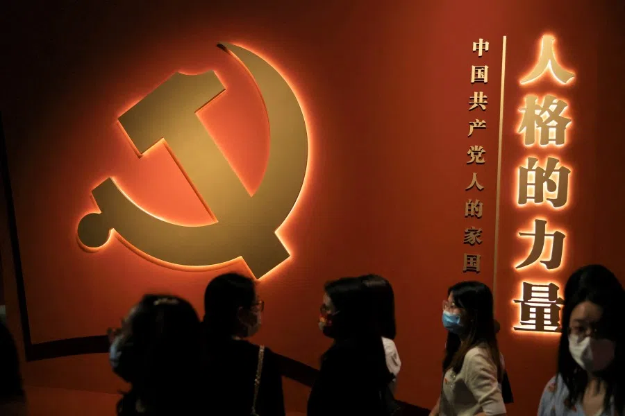 Visitors stand near the party emblem at an exhibition on the Chinese Communist Party ahead of its 101st founding anniversary, at the National Museum in Beijing, China, 30 June 2022. (Tingshu Wang/Reuters)