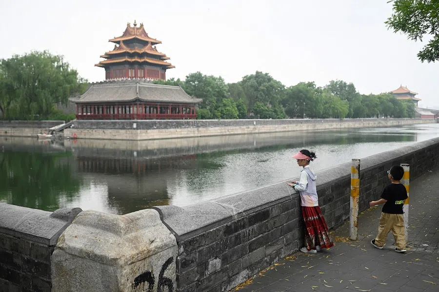 Two children look at a corner tower outside the Forbidden City in Beijing, China, on 20 June 2024. (Wang Zhao/AFP)