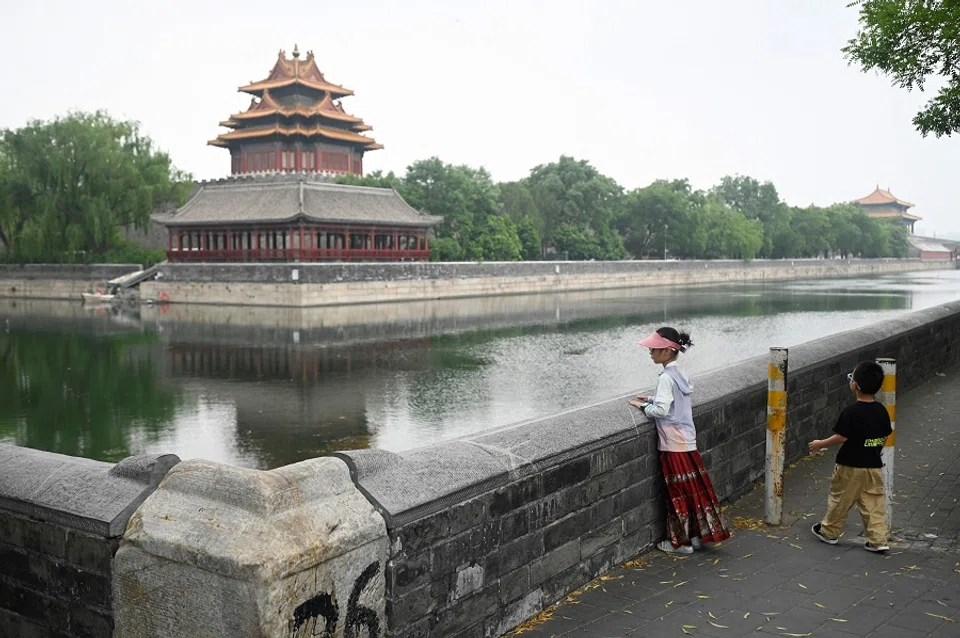 Two children look at a corner tower outside the Forbidden City in Beijing, China, on 20 June 2024. (Wang Zhao/AFP)