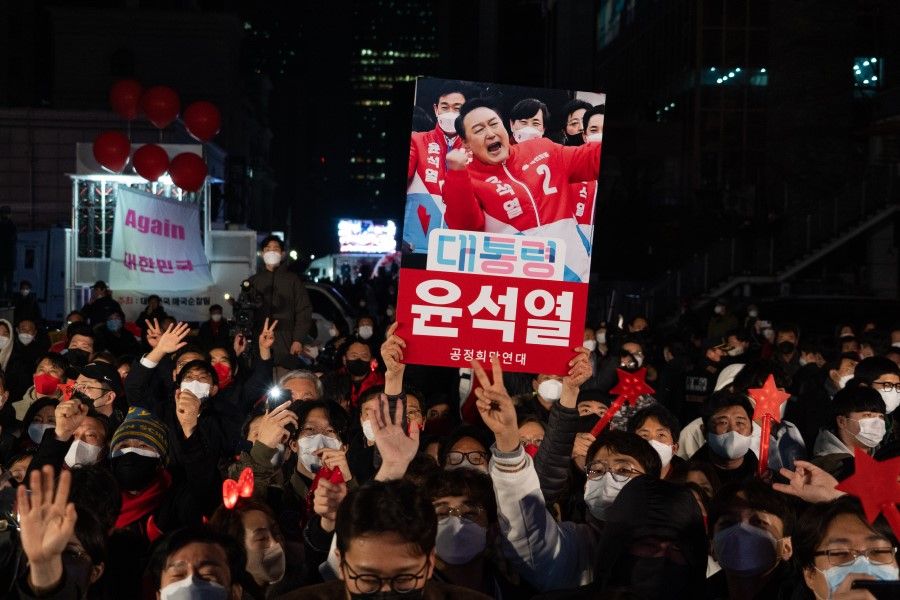 Supporters of Yoon Seok-youl, South Korea's president-elect, outside the People Power Party headquarters in Seoul, South Korea, 9 March 2022. Former top prosecutor Yoon Suk-yeol won the election as South Korea's president, returning the conservative opposition to power after five years and signalling a more hawkish turn in the country's relations with China and North Korea. (SeongJoon Cho/Bloomberg)