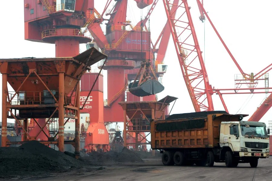 Imported coal is seen lifted by cranes from a coal cargo ship onto a truck at a port in Lianyungang, Jiangsu province, China, 26 July 2018. (Stringer/Reuters)