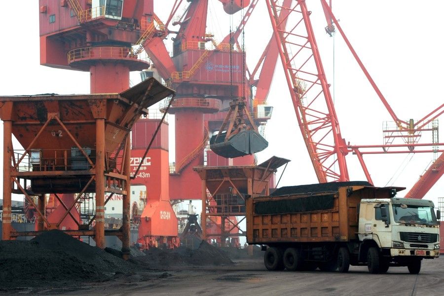 Imported coal is seen lifted by cranes from a coal cargo ship onto a truck at a port in Lianyungang, Jiangsu province, China, 26 July 2018. (Stringer/Reuters)