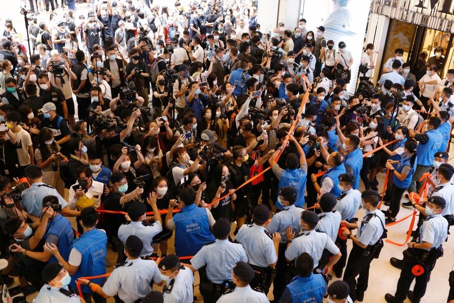 Police try to disperse media and pro-democracy supporters after authorities denied permission for a protest rally during the 24th anniversary of the former British colony's return to Chinese rule, on the 100th founding anniversary of the Communist Party of China, in Hong Kong, 1 July 2021. (Tyrone Siu/Reuters)