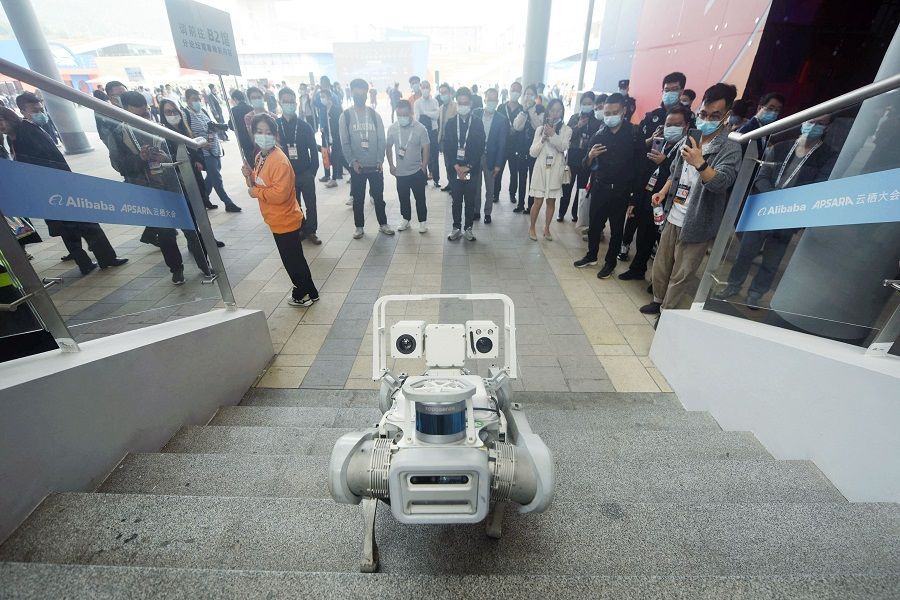 People watch a robotic dog at the Apsara Conference, a cloud computing and artificial intelligence (AI) conference, in Hangzhou, Zhejiang province, China, on 3 November 2022. (AFP)