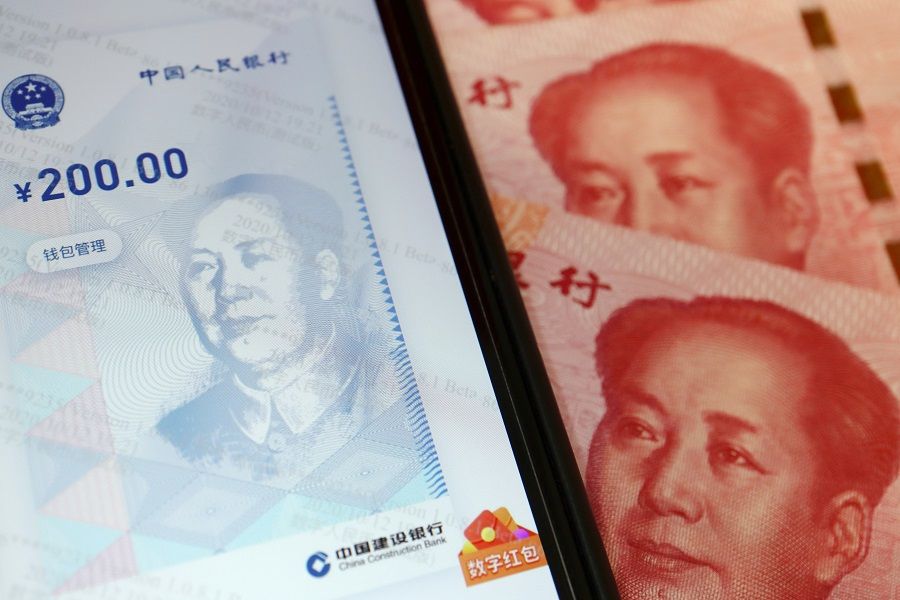 China's official app for digital yuan is seen on a mobile phone next to 100 RMB banknotes in this illustration picture taken on 16 October 2020. (Florence Lo/Illustration/File Photo/Reuters)