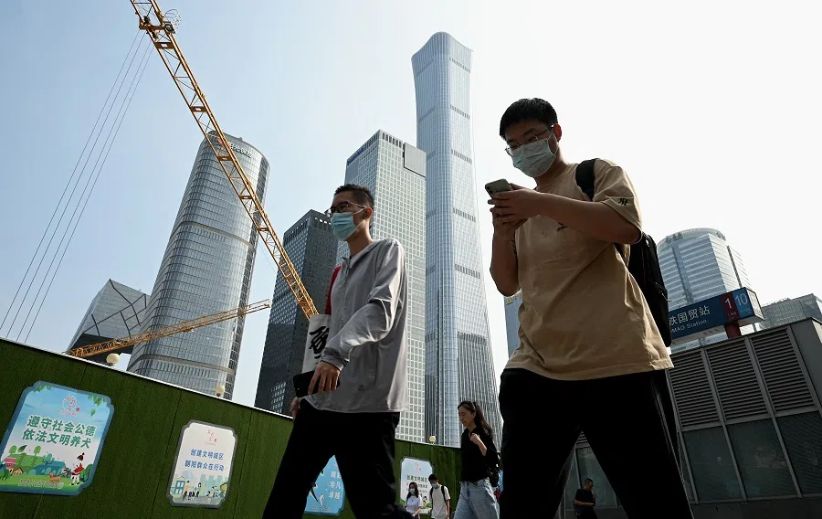 People walk along a street in Beijing, China, on 26 July 2022. (Noel Celis/AFP)