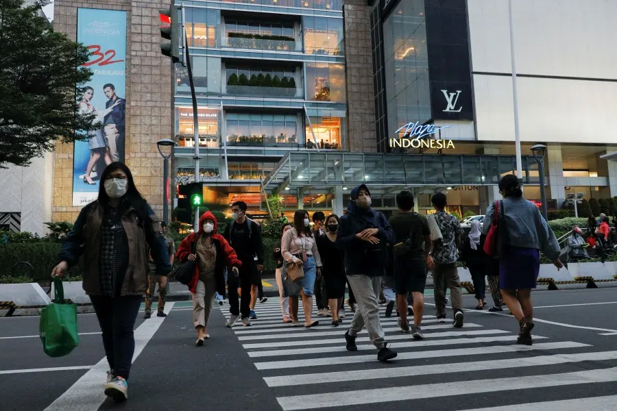 People cross a main road outside a shopping mall during afternoon rush hour in Jakarta, Indonesia, 30 November 2022. (Willy Kurniawan/Reuters)